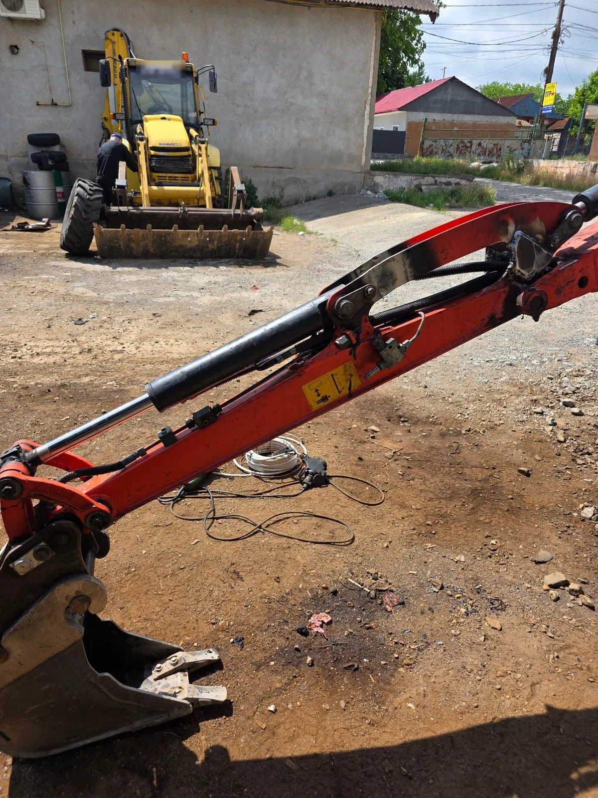 Brațul miniexcavatorului Kubota după reparație, în curtea atelierului